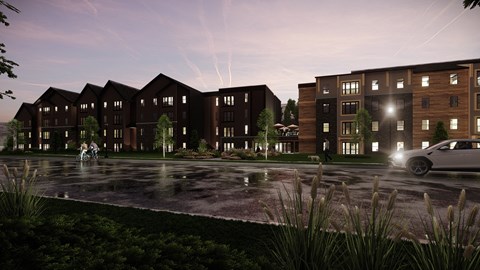 A modern apartment complex with a car parked in front.