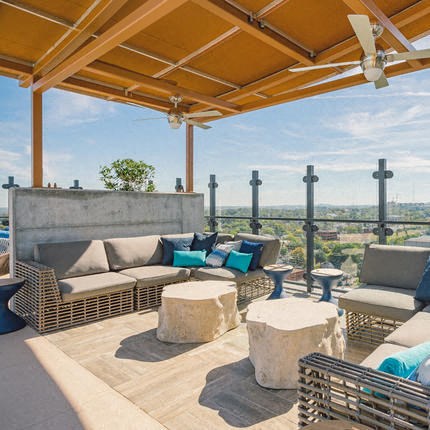 a patio with couches and tables on a roof