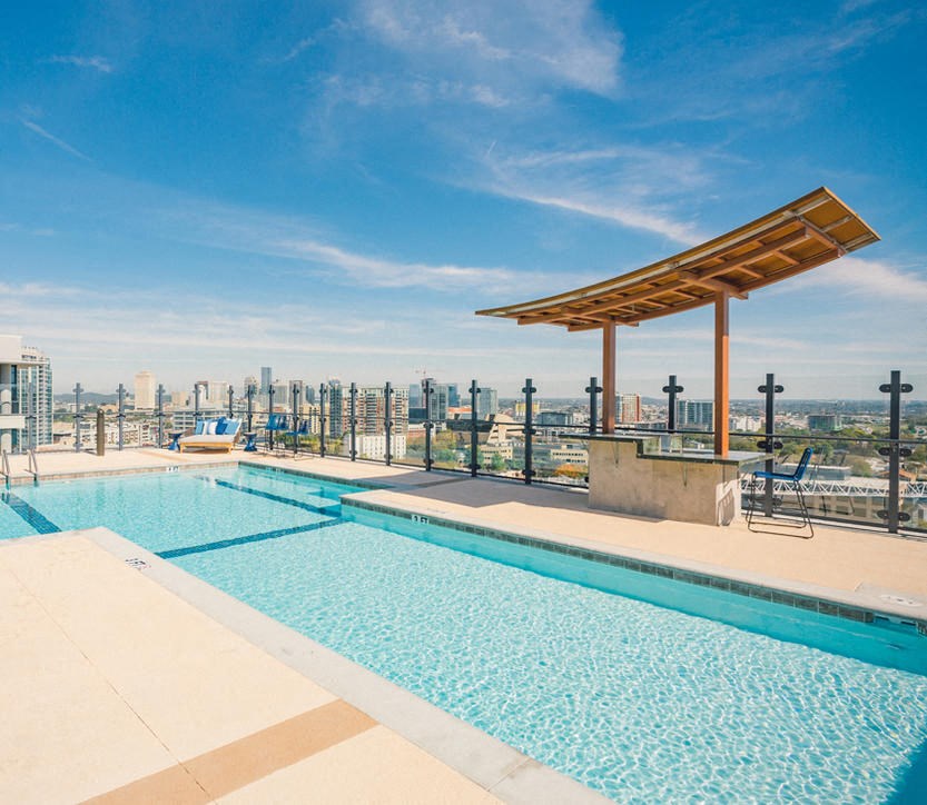 the pool on the roof of the building has a view of the city