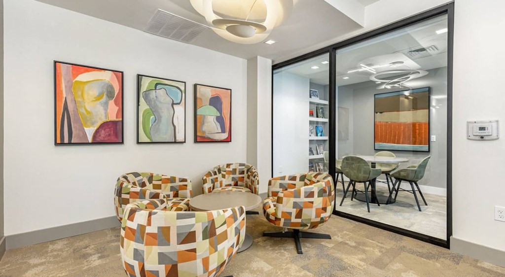 Social area with chairs and a table and a glass door