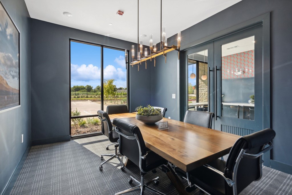 A conference room with a long table and chairs.