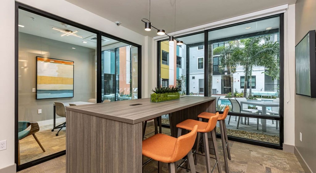 a bar with orange chairs in a room with large windows