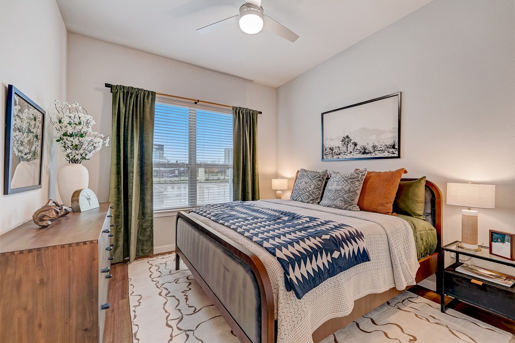 A bedroom with a large bed and a ceiling fan.
