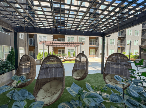 A patio with a roof and chairs.