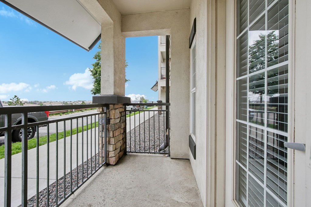 A balcony with a black railing and a stone pillar.