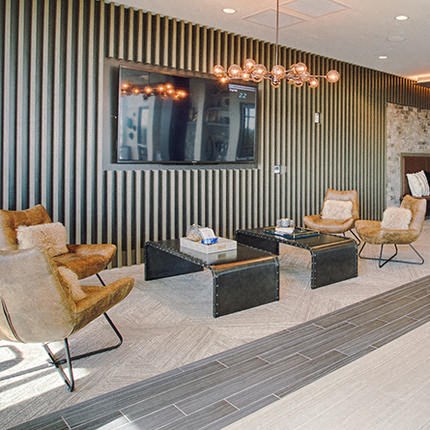 a living room with chairs and tables and a television