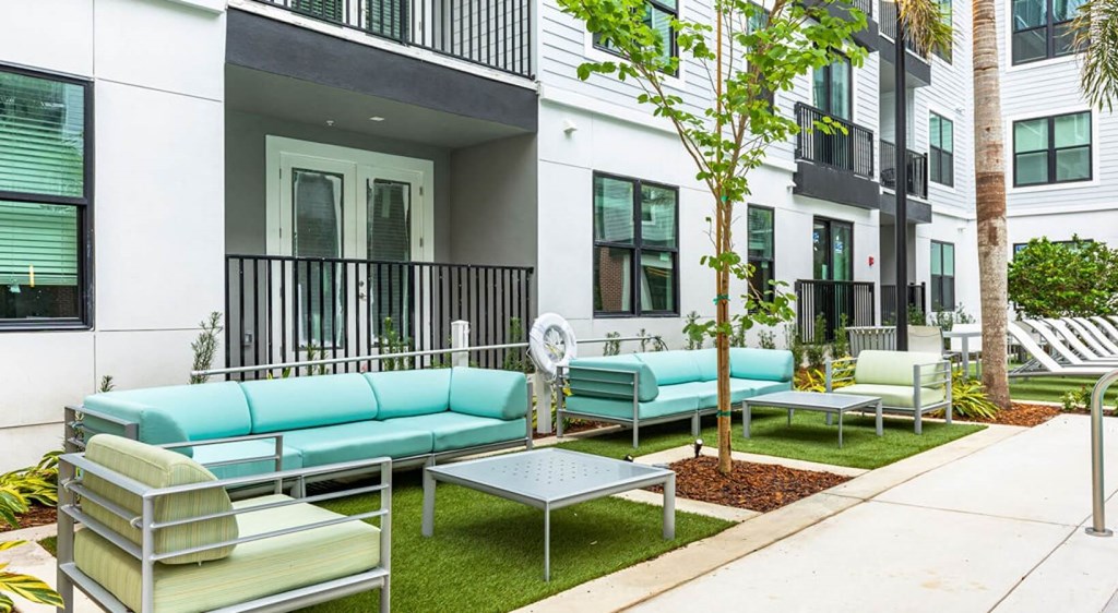 a patio with couches and chairs outside of a building