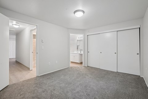 A spacious room with a grey carpet and white walls.