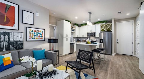 a living room and kitchen with a couch and a table