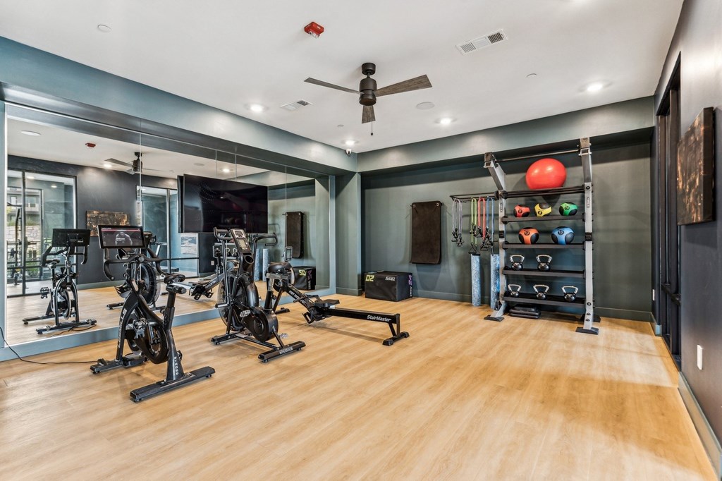 A gym with exercise bikes and a mirror on the wall.