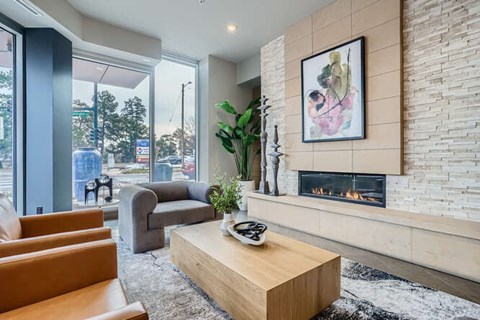 A living room with a fireplace and a painting on the wall.