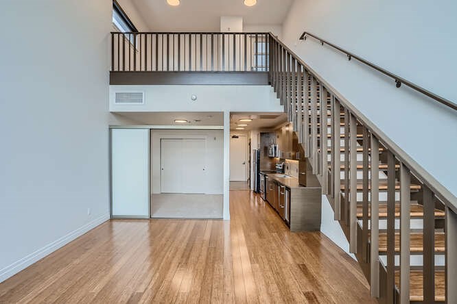 A spacious interior with a staircase and a kitchen area.