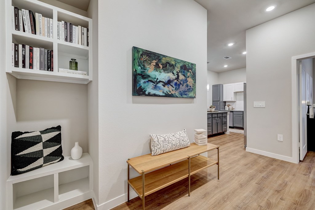 A living room with a wooden bench and a painting on the wall.