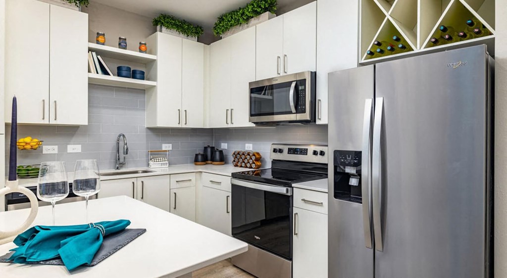 a kitchen with stainless steel appliances and a white table