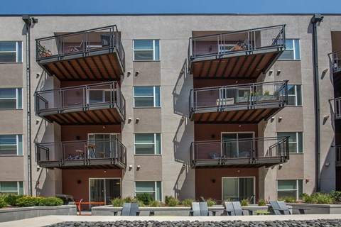 A modern apartment building with balconies and a pool in front.