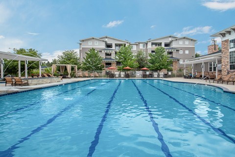 A large swimming pool in front of apartment buildings.