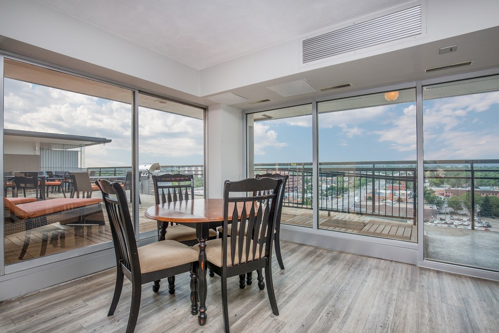 Resident lounge area with table and chairs surrounded by large windows