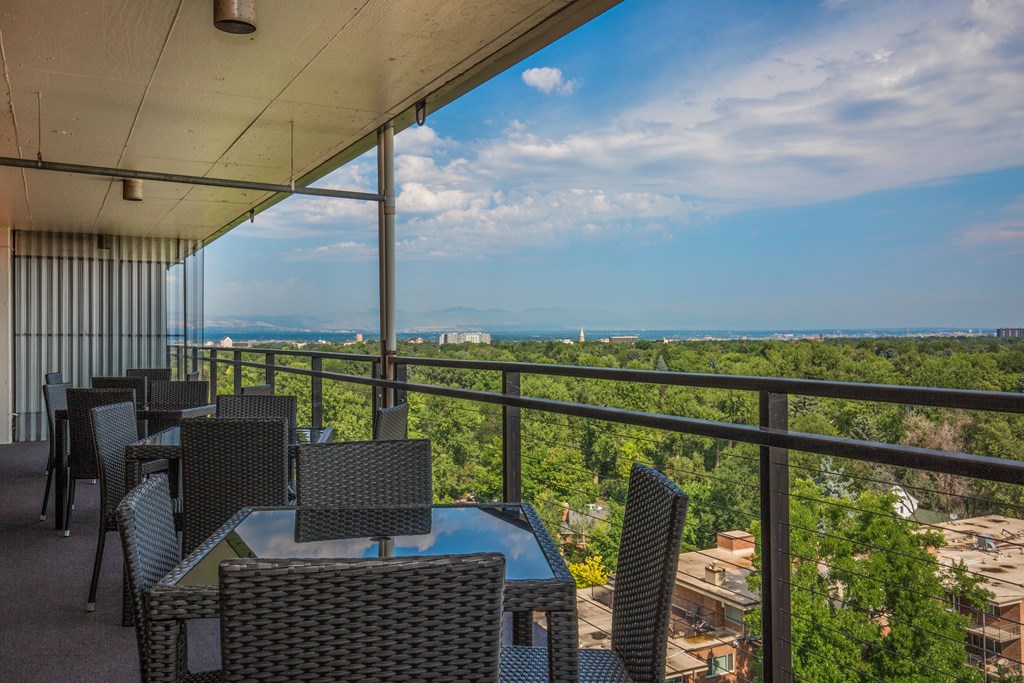 Rooftop deck with tables and chairs with a view of the trees
