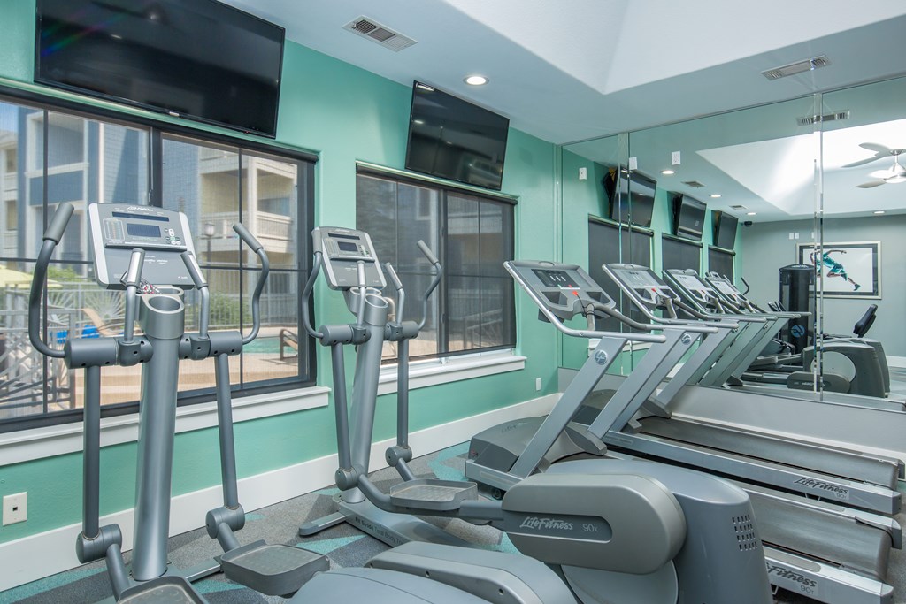 A gym with treadmills and elliptical machines.