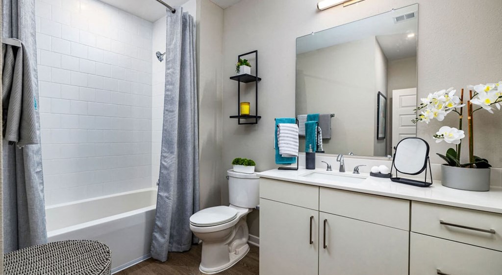a bathroom with a toilet and a shower and a sink