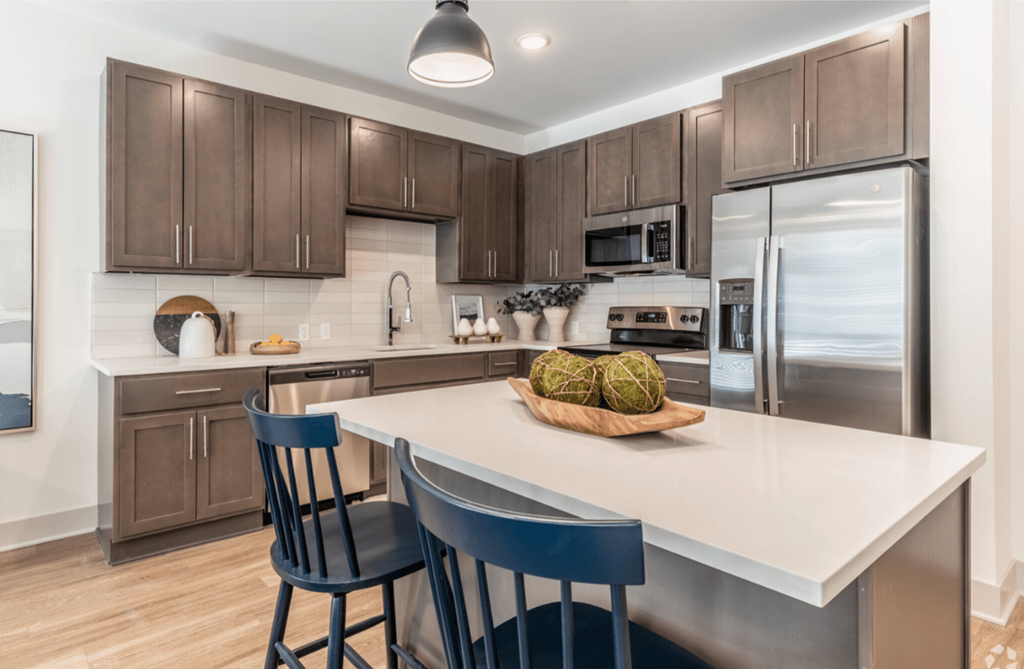 A kitchen with a white countertop and brown cabinets.