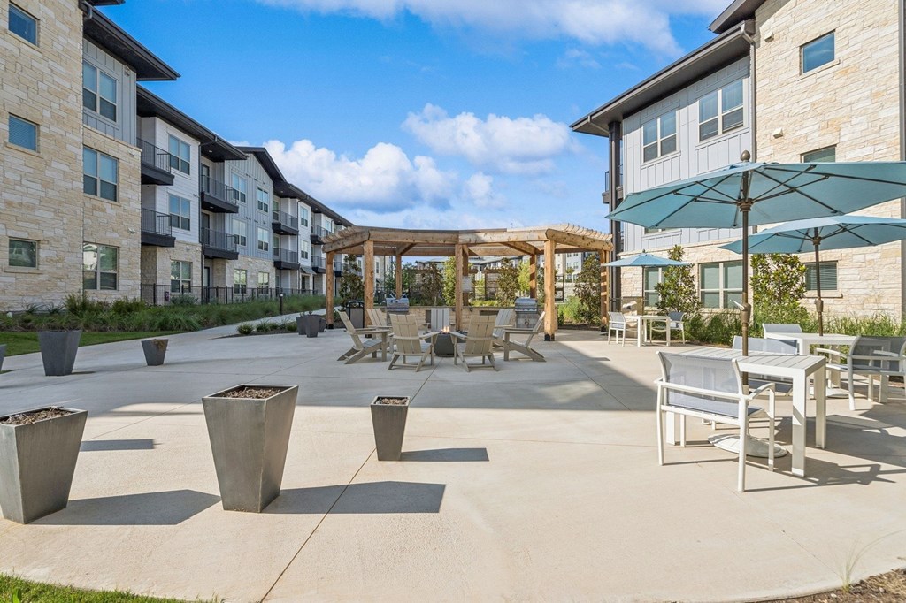 A patio area with a table and chairs and a pergola.