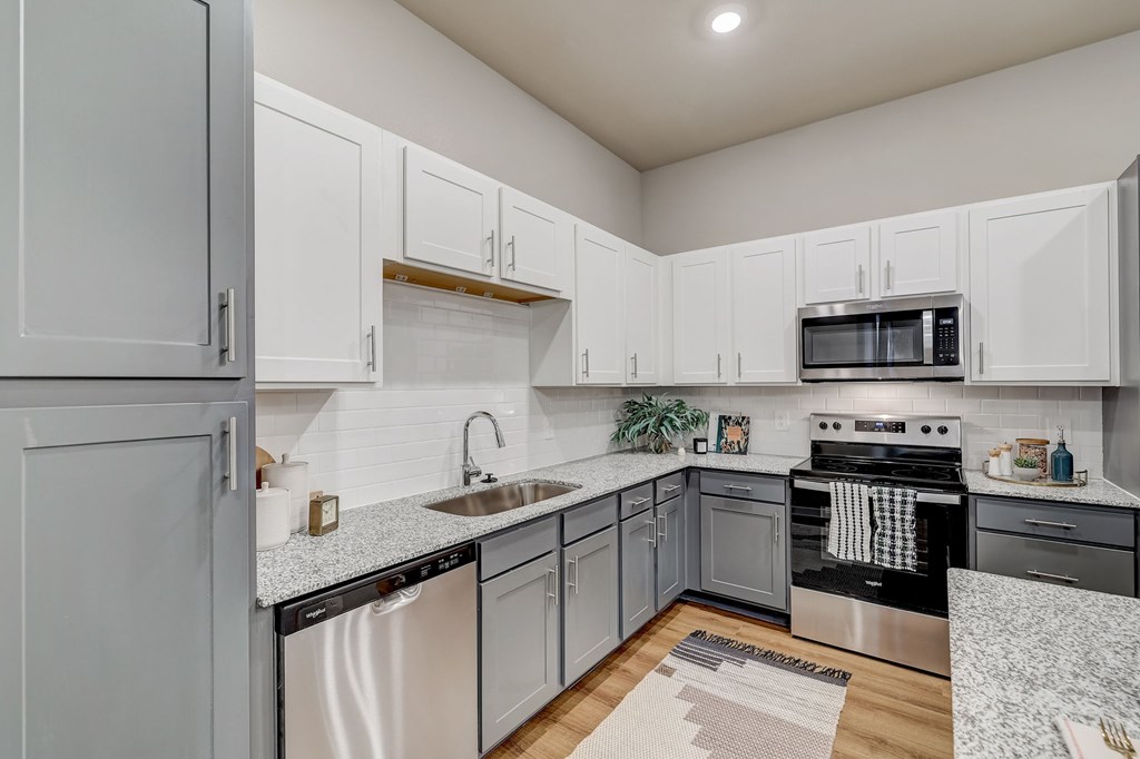 A kitchen with white cabinets and a black stove top oven.