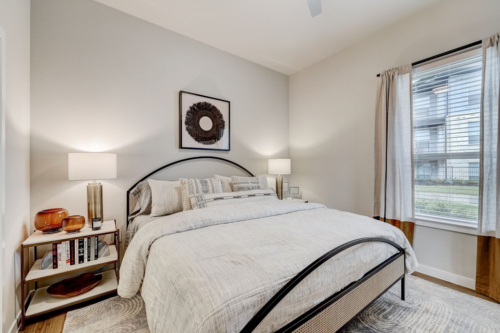 A bedroom with a large bed and a wreath on the wall.