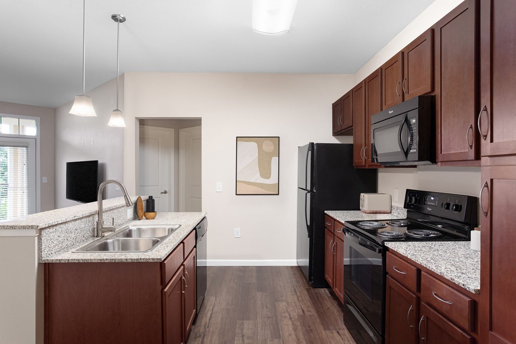 full kitchen with black appliances and granite counter tops at the flats at obsidian
