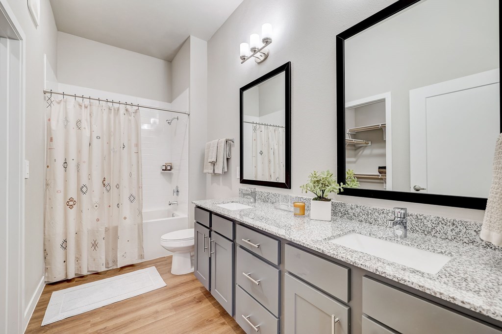 A bathroom with a white toilet, a sink, and a shower with a curtain.