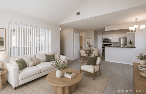 A living room with a white couch and a wooden coffee table.