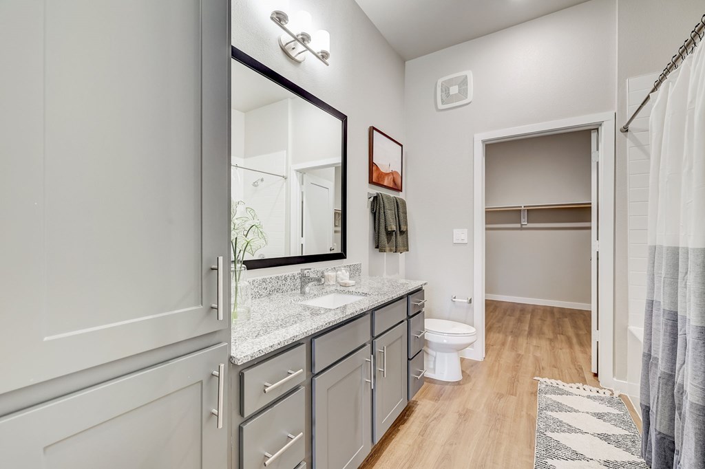 A bathroom with a white toilet, sink, and a mirror.