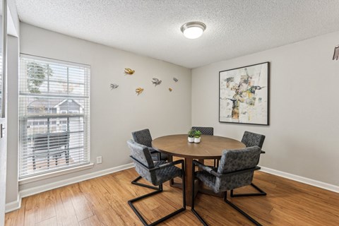 A dining room with a table and chairs.