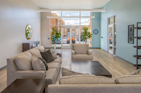 clubhouse lounge with a couch, chair, and a mirror on the wall.