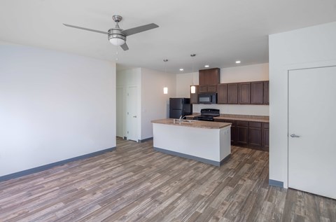 A modern kitchen with a wooden floor and white walls.