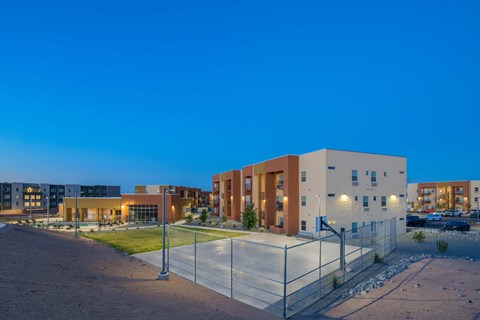 A modern building complex is illuminated at dusk.