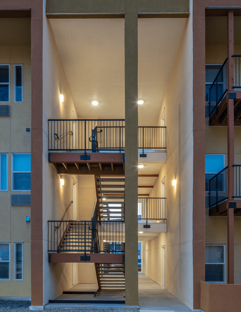 A staircase with a metal railing leads to a balcony.