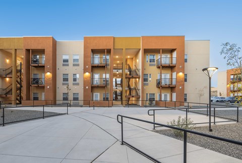 A modern apartment complex with a courtyard in the foreground.