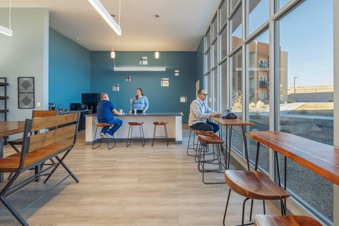 A man in a blue shirt is sitting at a table in the leasing office