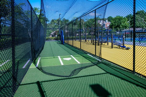 A tennis court with a green surface and a blue sky in the background.