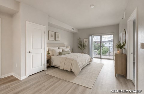 A bedroom with a large bed and a sliding glass door.