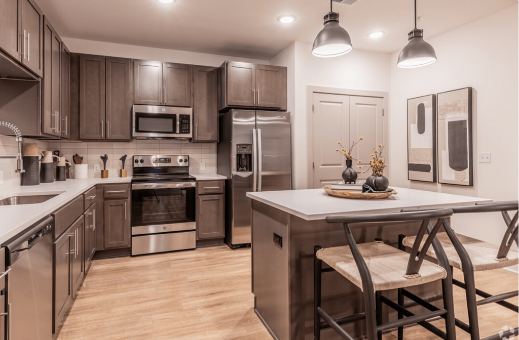 A modern kitchen with a wooden table and stainless steel appliances.
