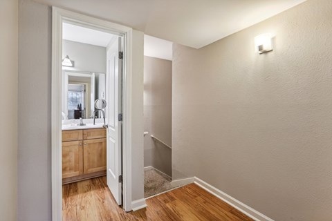 A bathroom with a wooden vanity and a white door.
