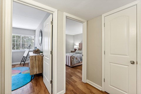 A white door is open to a room with a bed and a chair.