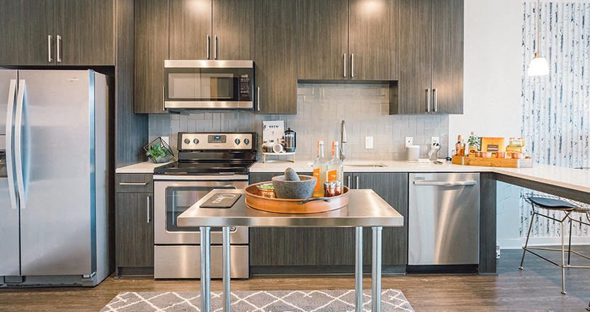 a kitchen with stainless steel appliances and a table