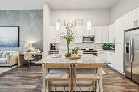 A modern kitchen with a dining table and chairs in the foreground.