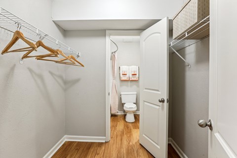 A small white bathroom with a toilet and a hanger on the wall.