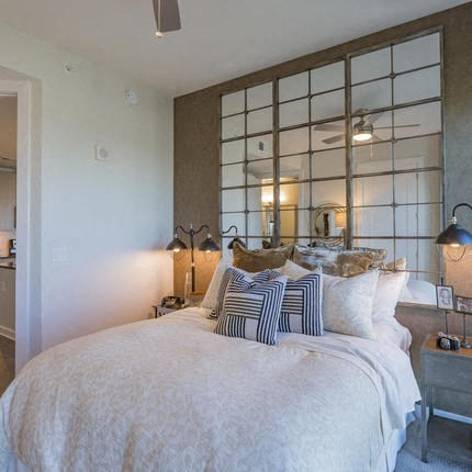 a bedroom with a large bed and a mirror