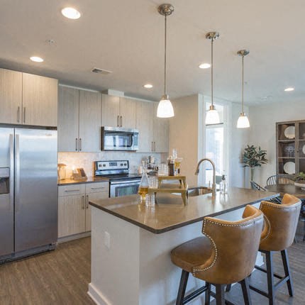 a kitchen with a bar and chairs and a refrigerator