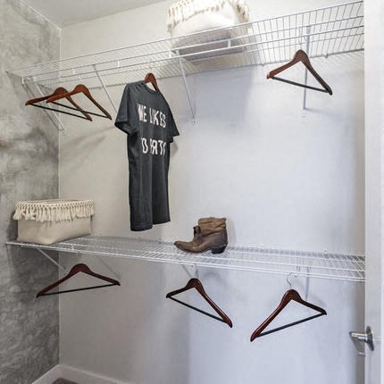 a closet with clothes and hangers and a shirt on a rack